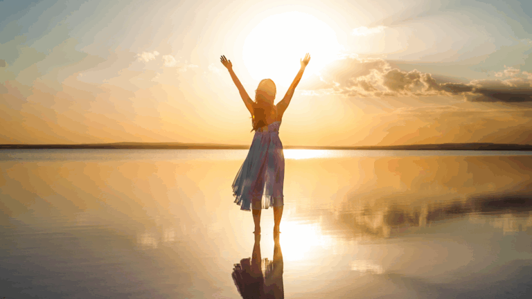 Femme levant les bras au soleil sur une surface d’eau calme au coucher du soleil – symbole de reconnexion et de transformation intérieure